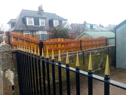View from inside garden of vertical fence with wavy top added to granite wall – bespoke garden privacy fencing