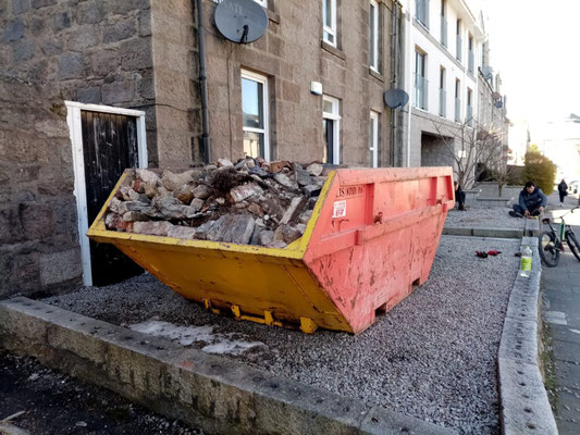 Red skip filled with rubble outside Bloomfield Road, Aberdeen.