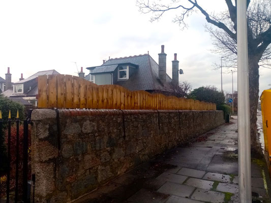 Vertical fence addition with wavy top on granite wall – bespoke garden fencing installation