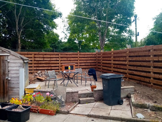1.8m high horizontal boarded fence in the corner of a garden – modern garden fencing installation