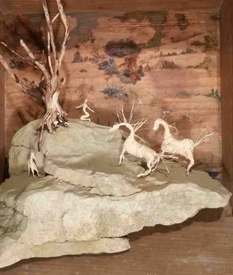 Scene of rocks with figures on and horses coming to meet them