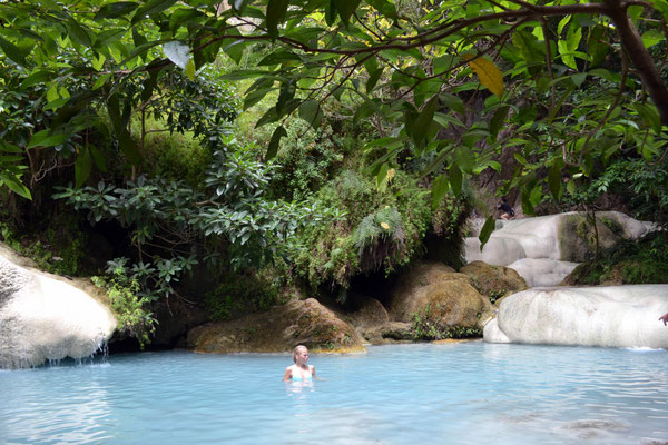 Frau schwimmt im tropischen Wasserfall