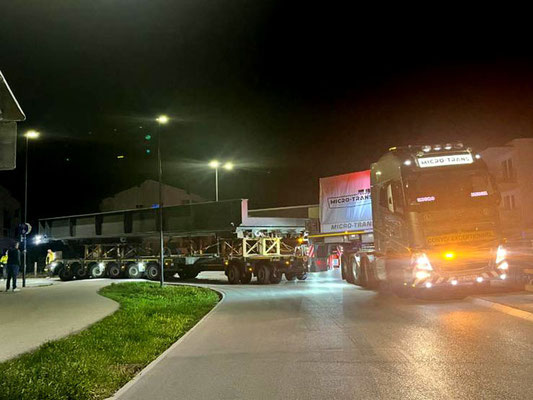 Rückansicht eines Schwerlasttransporters mit verhüllten, blauen Ladung auf einer Autobahn