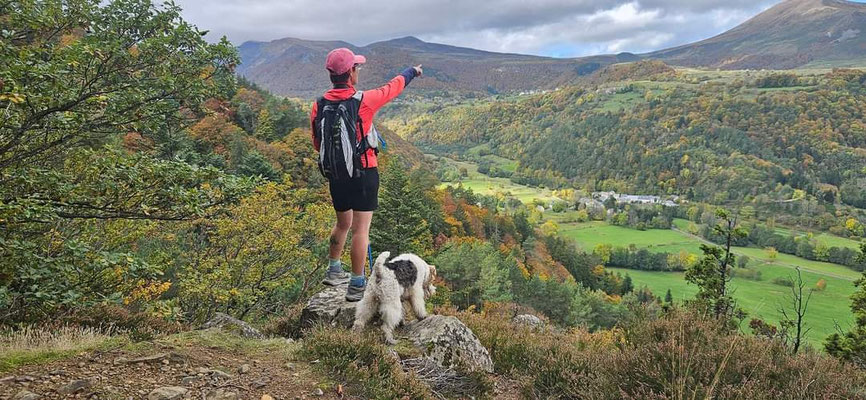 randonneuse ave un chien pointant la Chaine des Puys
