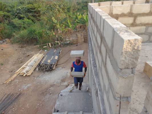 Die Ziegelsteine für den weiteren Ausbau werden auf der neuen Treppe nach oben getragen