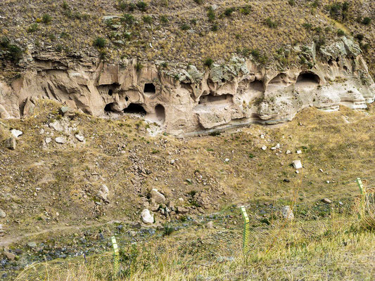  numerous caves dug into cliffs, as well as fortifications. A modern border fence can be seen at bottom center