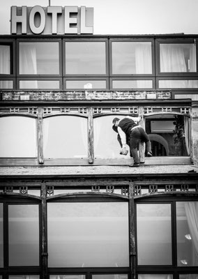 Tbilisi, Georgia - a clerk cleans the outside windows of the Kopala Hotel very adventurously