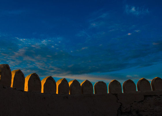 The top of the walls and towers are lined with toothed parapet ...