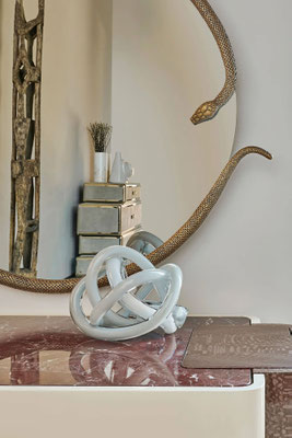 Detail of Morelia Mirror designed by Luca Tornaghi for Roberto Cavalli Home Interiors, highlighting the textured metallic surface and the sinuous movement of the serpent-inspired frame.