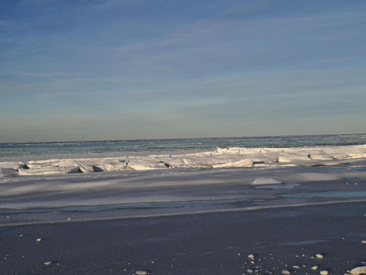 Auf dem Weg zum Nordstrand in Prerow. Eine weiße Winterlandschaft mit einer zugefrorenen Ostsee und Eisschollen