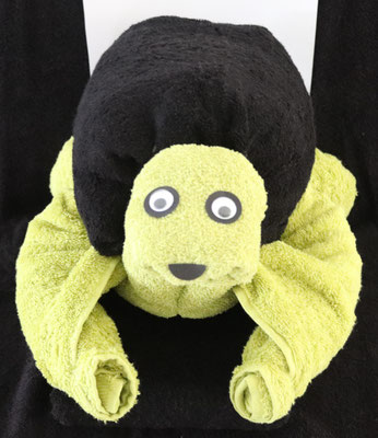 Handtuchfigur als große Schildkröte, hergestellt aus zwei Duschtüchern in grün und einem schwarzen Handtuch als Panzer