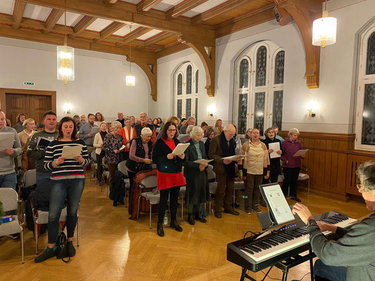 Die Anwesenden singen internationale Weihnachtslieder mit Hingabe.