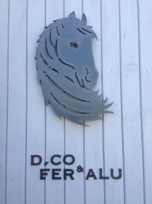 Logo mural en lettre métal découpée représentant une tête de cheval stylisée et l’inscription « D.CO FER & ALU »,