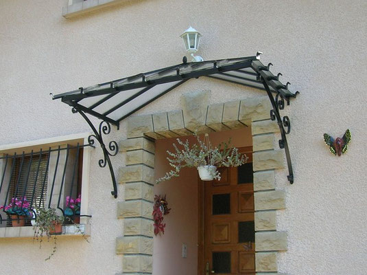 Marquise en aluminium moderne et légère, couvrant une porte d’entrée pour la protéger des intempéries