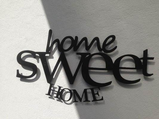 Lettre métal découpée noire formant l’expression « home sweet home » en écriture décorative, exemple de découpe des métaux pour décoration murale