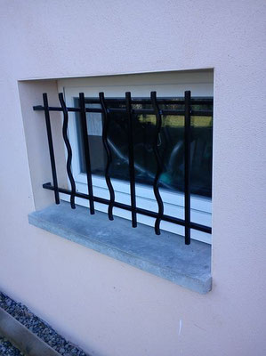 Grille de défense pour fenêtre en acier noir assurant sécurité et design classique.