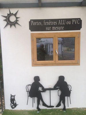 Décoration murale en lettre métal découpée représentant deux silhouettes à une table, sous une fenêtre