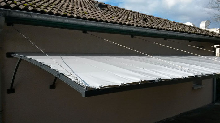 Auvent de 7M par 3M dans une crèche, sans poteaux avec une toile tendue  fixé directement dans le mur.