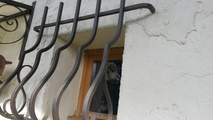 Grille de défense pour fenêtre en fer forgé, alliant sécurité et charme traditionnel.