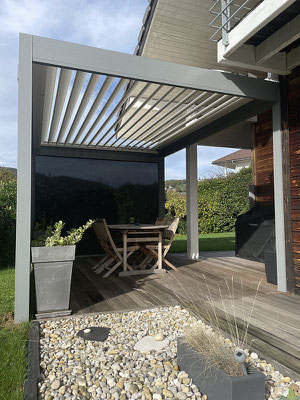 Si la discrétion est le maître mot dans la plupart des projets, l'intégration d'une pergola bioclimatique  et son contraste peut aussi être de mise, et aider à relooker une maison, à lui donner un coup de jeune. Réalisation secteur Novalaise