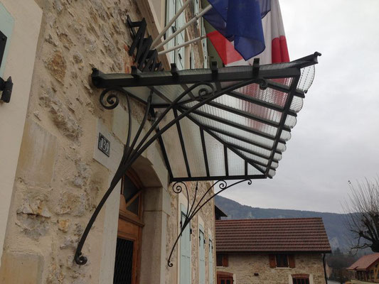 Marquise décorative en fer forgé noir assurant une protection élégante contre la pluie.