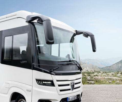 Frontansicht eines weißen MORELO Luxus-Reisemobils vor einer Berglandschaft