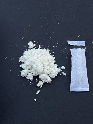 weisse_Fuellung_eines_Nikotinbeutels_mit_leerer_Verpackung