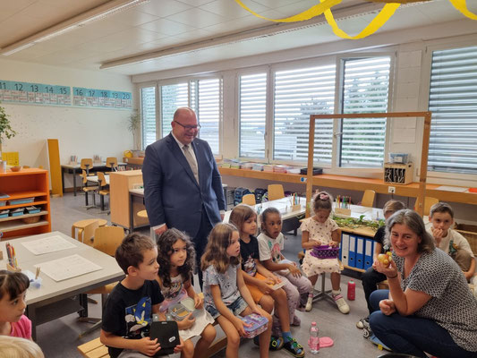 Bildungsdirektor Armin Hartmann blickt den neuen Erstklässlerinnen beim Schulstart über die Schulter. (Bild: Karin Döös)