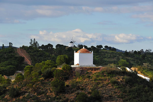 Auf dem vorderen Hügel steht eine Friedhofkapelle mit zugehörigem Friedhof. Dahinter eine der klassischen Windmühlen Portugals, denen man immer wieder begegnet, welche aber kaum mehr betrieben werden.
