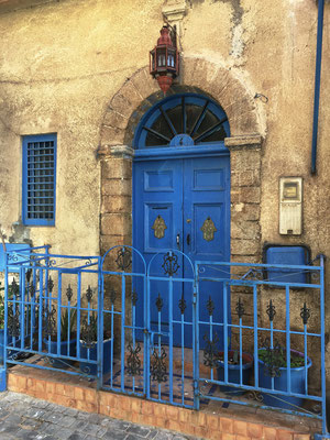 Hauseingänge mit blau gestrichenen Schmideisengittern sind hier typisch. Die beiden Hände (der Fatima) an den Türen, sollen das Haus beschützen. 