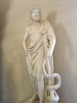 Die absolut zentrale Figur in Epidaurus ist "Äskulap" der griechische Gott der Heilkunst aus der Antike, welcher hier besonders verehrt wurde.
