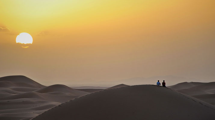 Den romantischen Sonnenuntergang erleben wir hoch auf dem Kamm einer Sanddüne. 