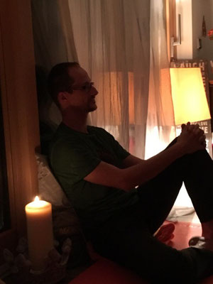 Jan wünscht sich gedanklich in seine Meditation bei Kerzenlicht, während er liest.