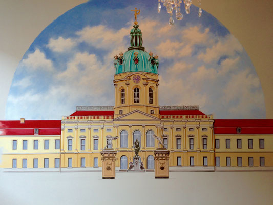 Handgemalte Wandgestaltung mit dem Schloss Charlottenburg Berlin und rankenden roten Rosenstöcken in einem klassisch-eleganten Schlafzimmer.