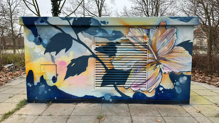 Künstlerisches Graffiti-Mural auf einem Trafohaus, das eine große, weiß-gelbe Hibiskusblüte und markante, dunkelblaue Blätter vor einem abstrakten, hellen Hintergrund zeigt. Professionelle Fassadengestaltung von Appolloart zur ästhetischen Aufwertung öffe