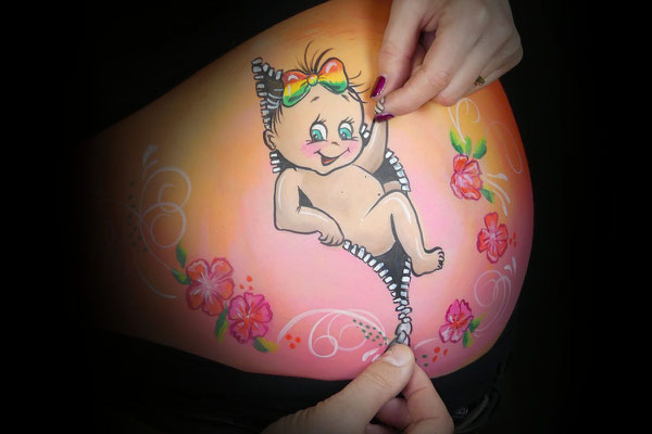 Baby meisje komt uit de rits als bellypaint