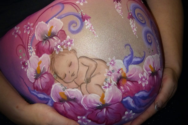 Een lieflijke bellypaint van een baby tussen de bloemen