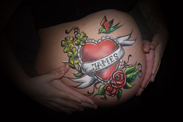 Stoere bellypaint met hartjes en bloemen in tattoo stijl