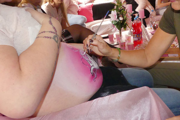 Aan het bellypainten op een babyshower