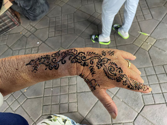 Brigitte lässt sich zu einer Henna-Verzierung der linken Hand überreden