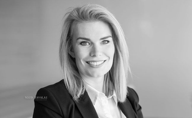 Professionelles Businessfoto einer blonden Frau im Blazer vor hellem Hintergrund, sympathisches Lächeln