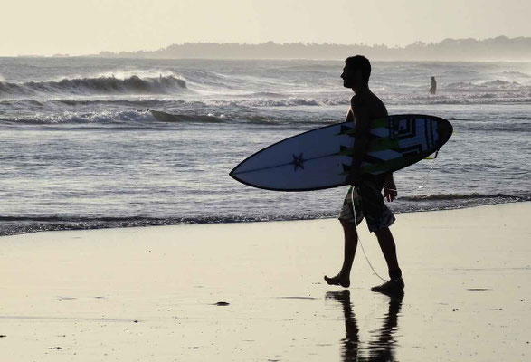 A surfer gazing at the waves, ready to ride Bali’s ocean swells.