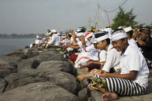 Children in ceremonial dress by the coast during a ritual