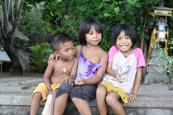 Three children sharing a laugh on the temple steps.