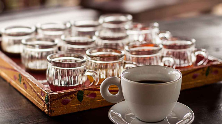 A cup of Balinese coffee with tea cups in the background, a taste of local tradition.