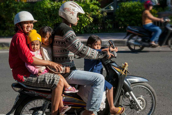 Local family of five riding together on a motorbike
