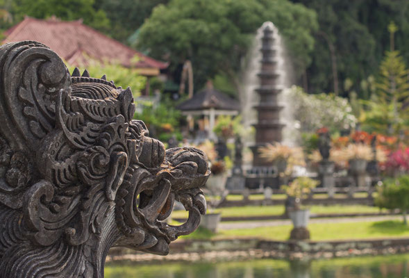 A carved stone guardian watching over the temple’s peaceful pond in Tirta Gangga