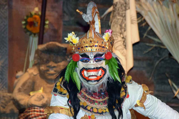 A Topeng dancer holding a fearsome mask, embodying Bali’s dramatic artistry.