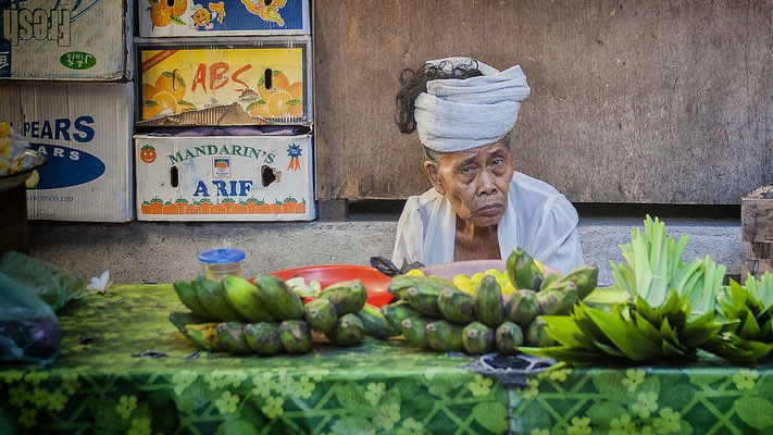Local woman selling tropical fruits at a traditional market.