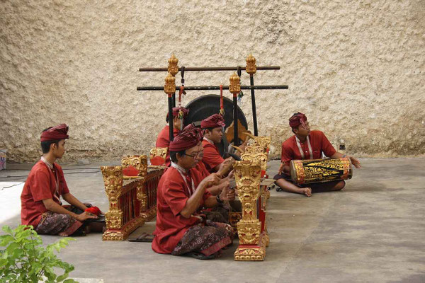 A small ensemble of gamelan musicians giving a spirited performance.